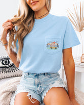 Person wearing a light blue t-shirt with a dog graphic and denim shorts in a casual setting.