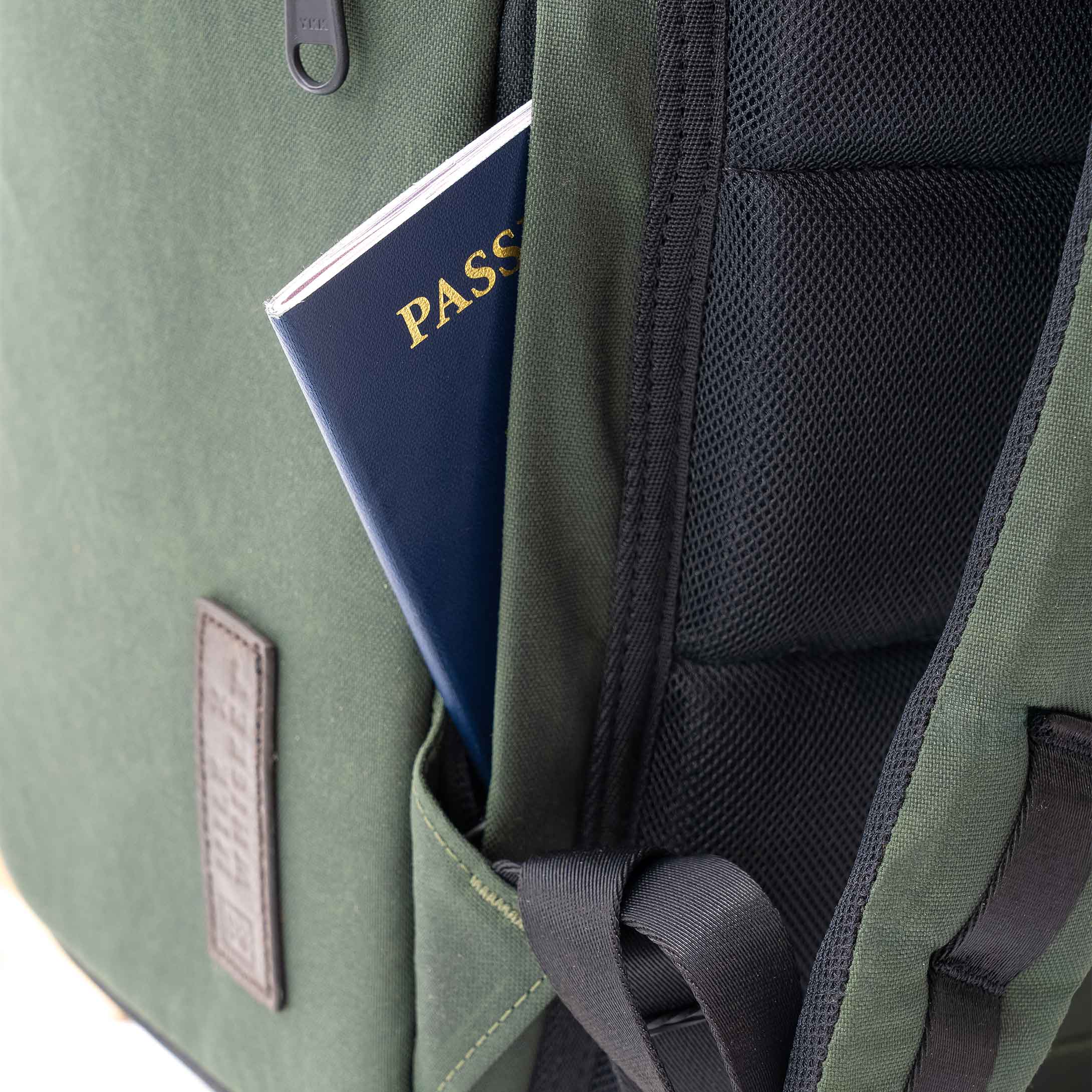 Green backpack with a passport sticking out of the front pocket on a white background