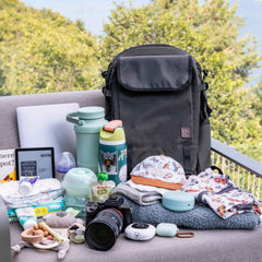 Backpack with baby gear on a couch outdoors