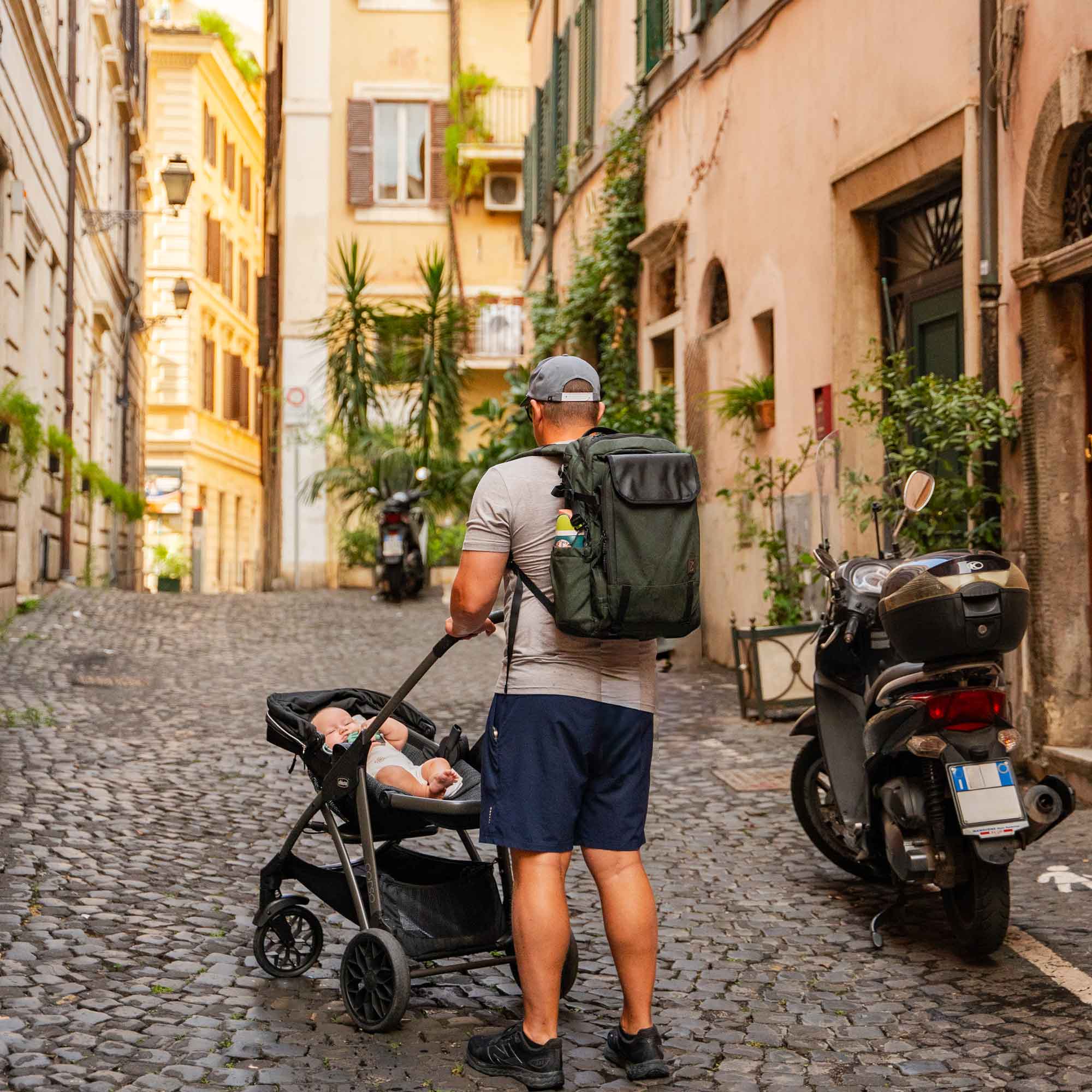 Man pushing a stroller with a baby in an urban setting