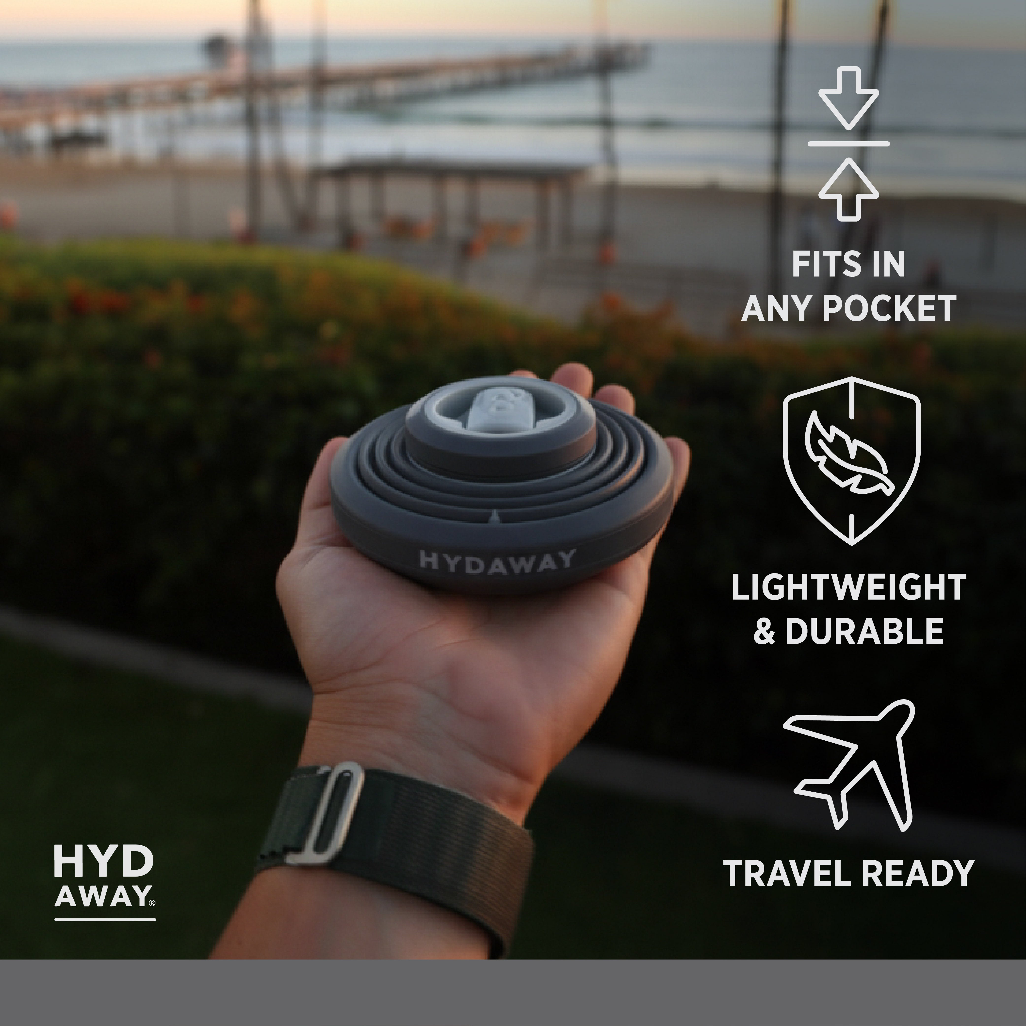 Hand holding a compactable water bottle with scenic background