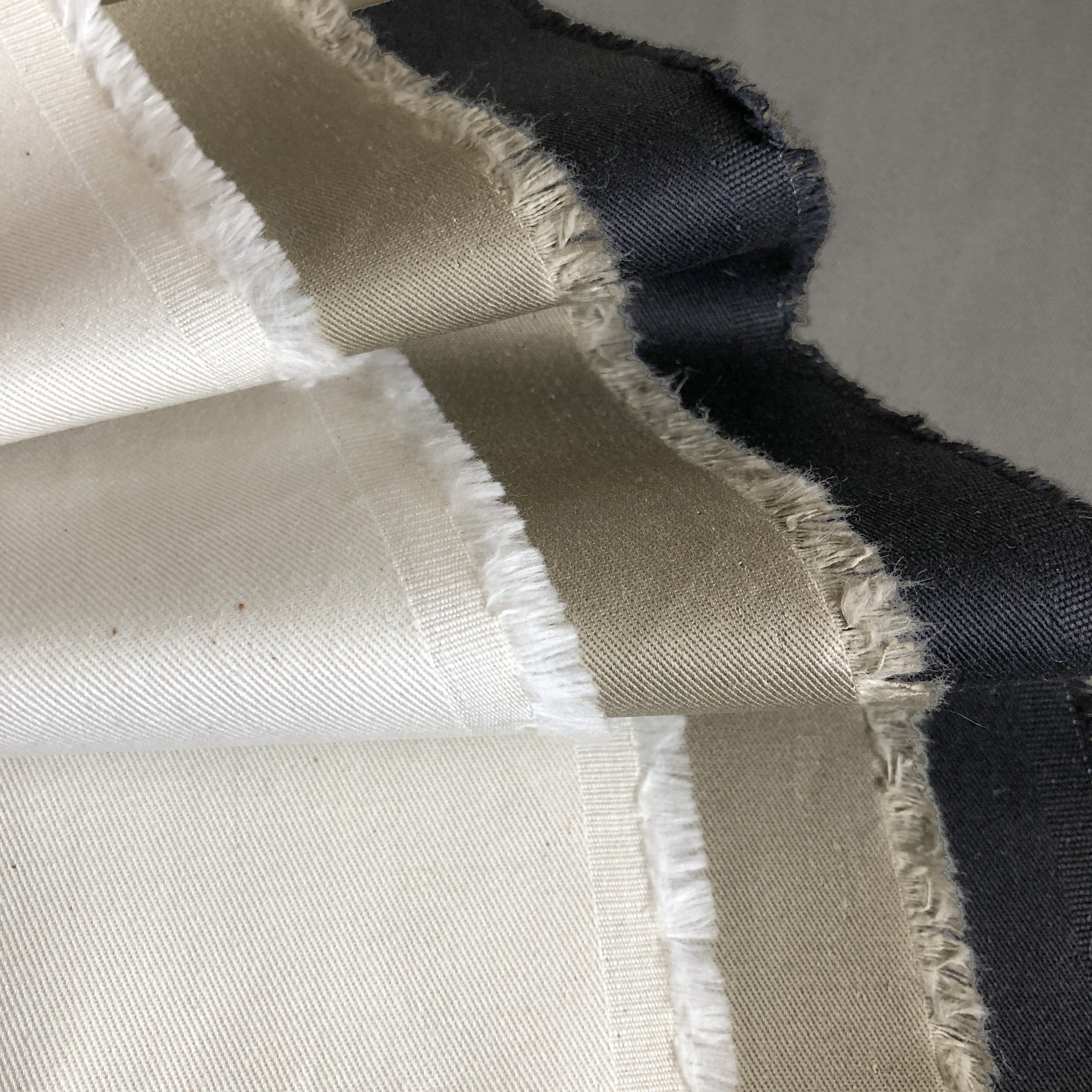 Close-up of fabric swatches in white, beige, and black.