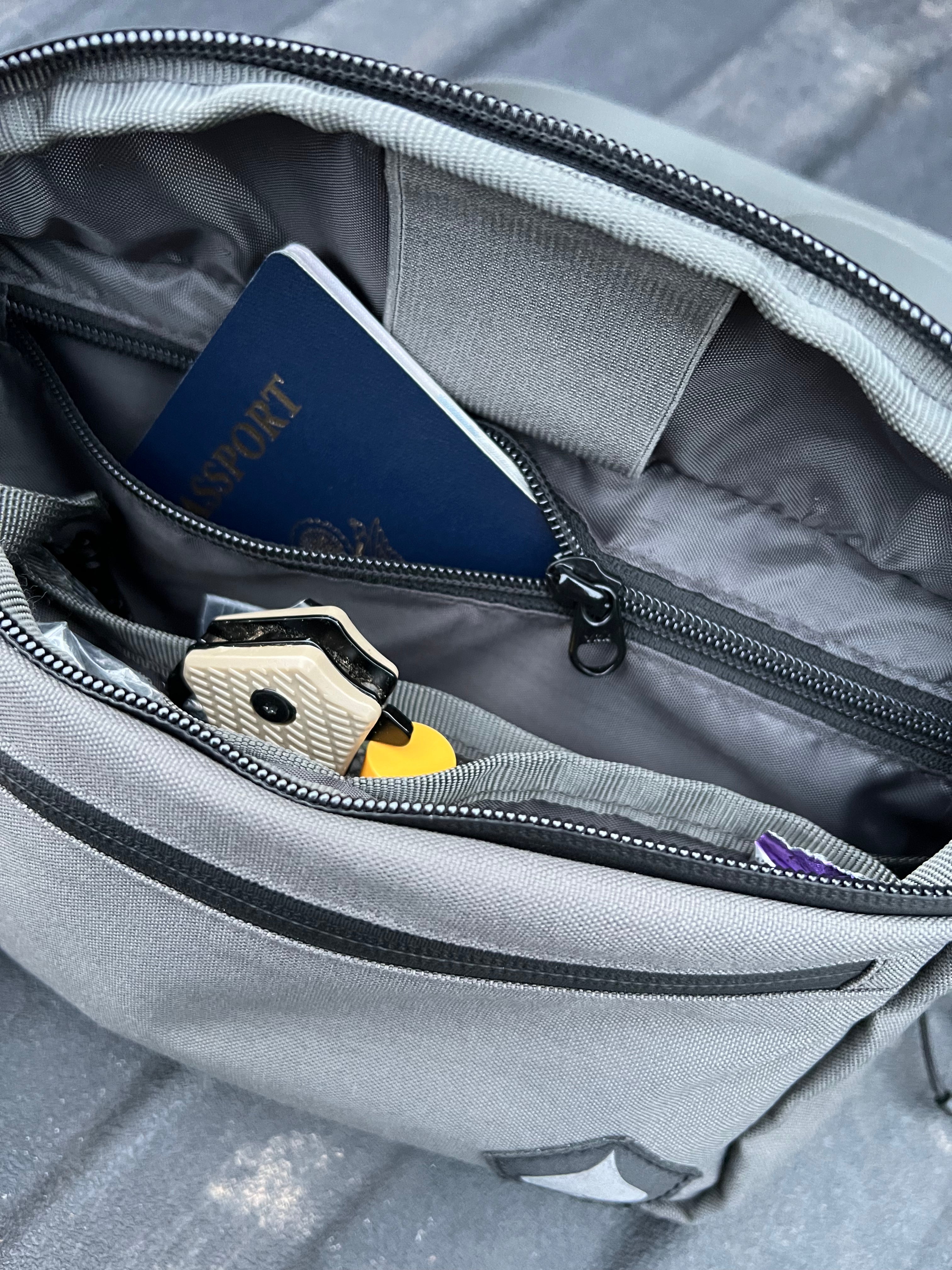 Gray backpack with a passport, keys, and phone inside