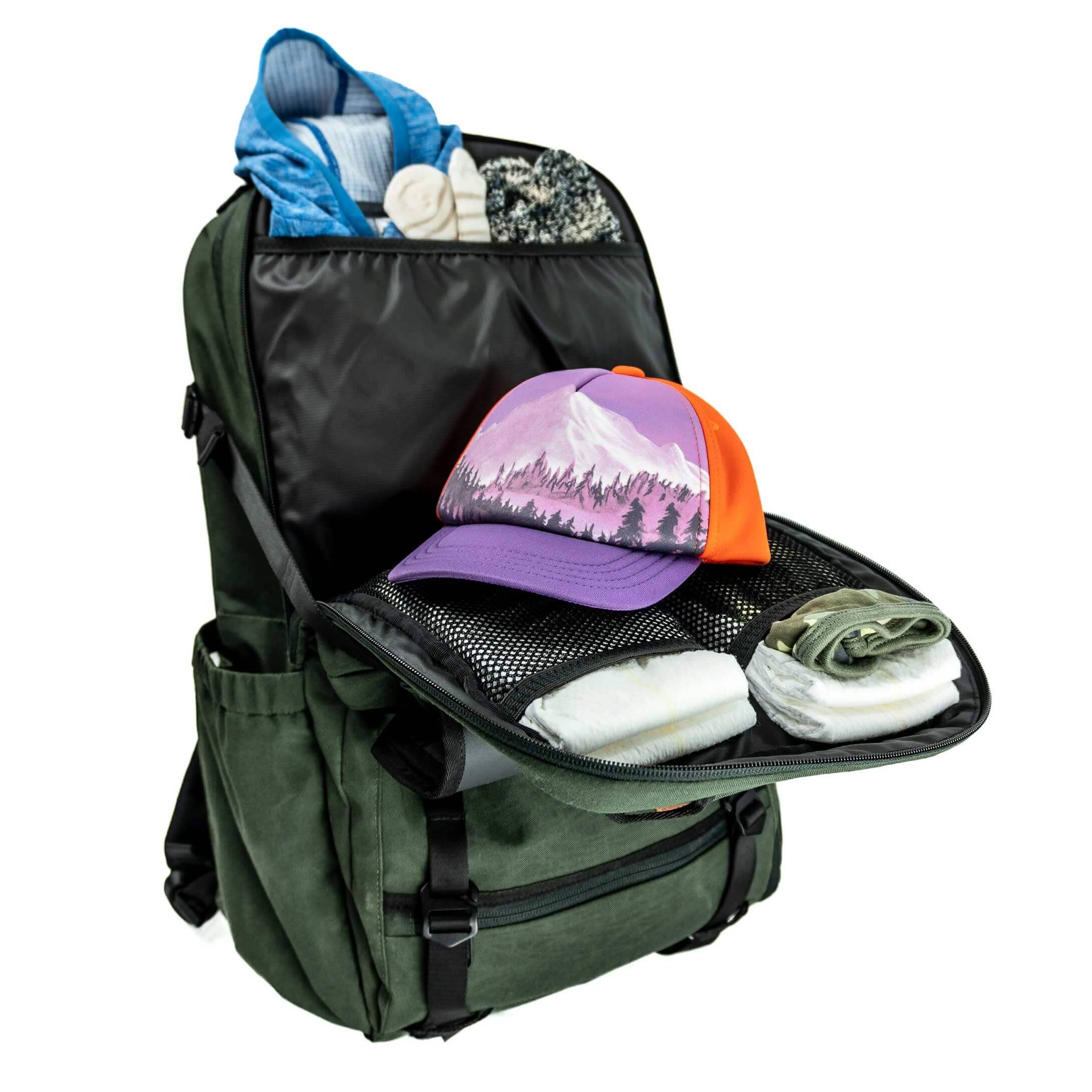 Green backpack with a purple and orange cap, blue shirt, and other items on a white background