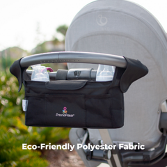 A black PrimalPasse Eco-Friendly Polyester Fabric stroller basket organizer hanging from a stroller handle outdoors, with a stroller seat in the background.