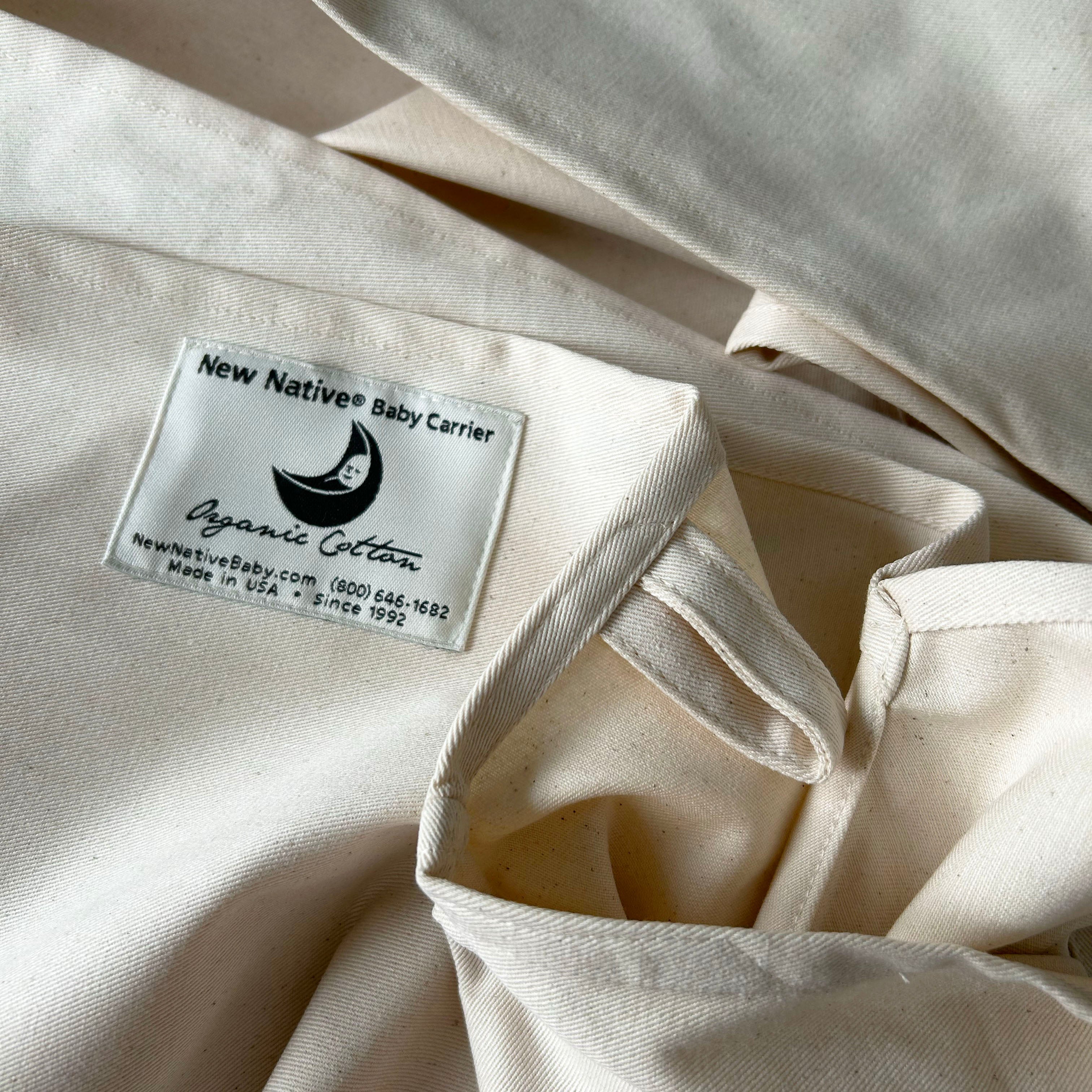 Close-up of a beige fabric with a label on it, featuring text and a logo.
